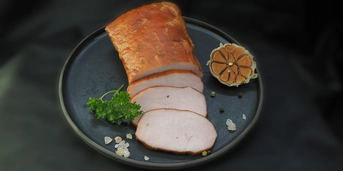 Sliced smoked pork loin on a dark plate